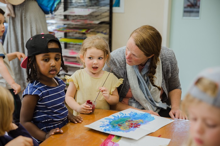Teacher J listening to a child